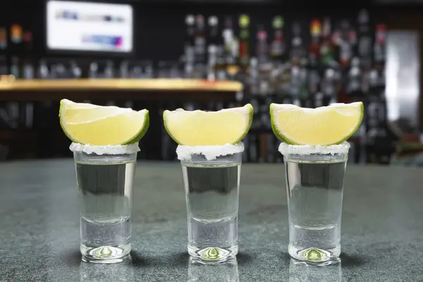 A shot of tequila with salt and lime. Tequila on the background of a Mexican beach. Golden Mexican Tequila. Copy space