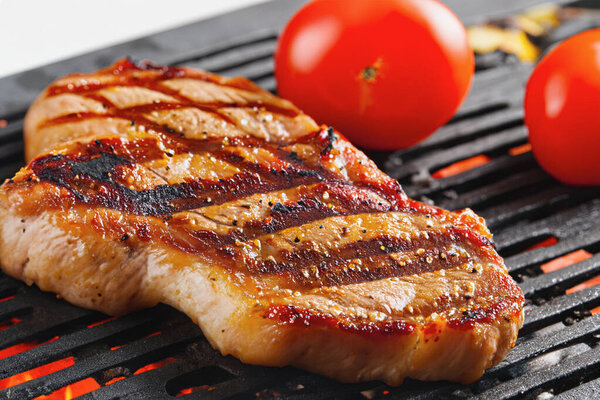 A delicious steak is prepared on the grill grate. Grilled beef fillet. Background with place for text