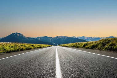 Dağlık bir bölgede bir yol. Güzel dağ manzarası. Dağlık bölgedeki otoyolun manzarası. Güzel bir arka plan. Güzel doğada yol manzarası. Gün batımı, gün doğumu