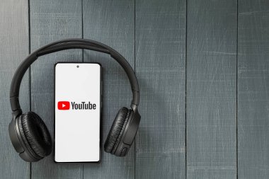 Varşova, Polonya - Mart 2024: Akıllı telefon ve kablosuz kulaklıklar. Kulaklıklı telefon. Boşluğu kopyala.