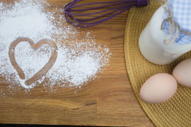 Un üzerine parmak çizilmiş bir kalp. Bir kalp beyaz un üzerinde bir parmak ile çizilir. Boşluğu kopyala