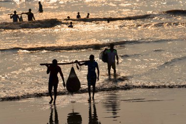 Mumbai, Hindistan / 10 Eylül 2017: Güney Asyalı Hintli balıkçılar Uttan Sahili 'nde satılmak üzere denize demirlemiş teknelerinden bir sürü balık taşıyorlar. 