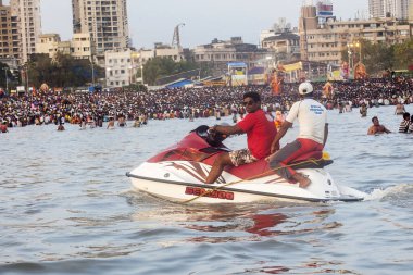 Hindistan, Maharashtra, Mumbai, Eylül 2009: Arap Denizi 'ndeki Girgaum Chowpatty' de Ganesh Nehri 'ne batırılırken jet ski üzerindeki cankurtaranlar.