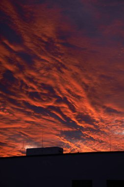 Binaların silueti ile kırmızı-turuncu gökyüzü
