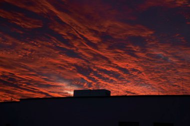 Binaların silueti ile kırmızı-turuncu gökyüzü