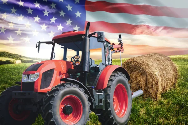National agricultural industry concept - idyllic farm field with hay bales and tractor on on the background of the USA flag (mixed).
