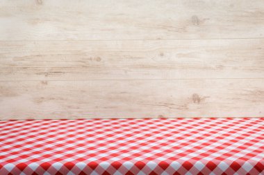 Kapalı alanda yemek pişirmek için şablon - açık ahşap arka planda klasik İtalyan kırmızı kareli masa örtüsü ile boş masa