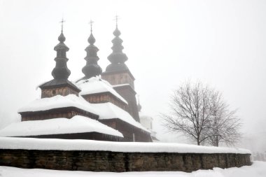 Old wooden Greek Catholic church of the Protection of Our Most Holy Lady from 1653 in Owczary, Poland on a foggy winter day
