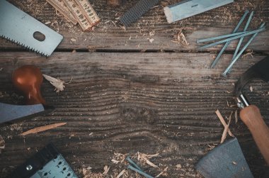 Geleneksel marangozluk aletlerinin üst görünümü eski ahşap bir masa üzerinde talaş tozuyla