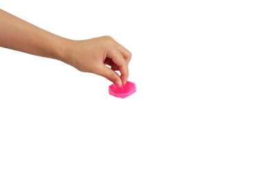 Çocuğun eli beyaz arka planda dönen bir kapağı tutuyor.