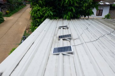 Metal bir çatıya kurulmuş küçük güneş panelleri