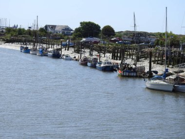 Kasabada tekne, yat ve binaların olduğu nehir manzarası