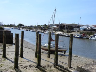 Kasabada tekne, yat ve binaların olduğu nehir manzarası