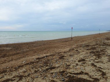 Deniz ufkuyla kumlu ve çakıllı sahilin manzarası