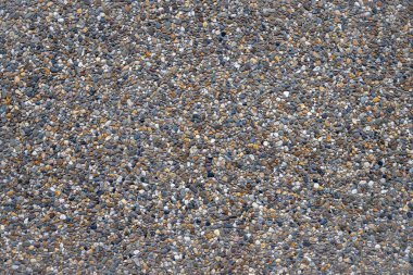 Colored gravel in a concrete facade plate as a full-screen background photo