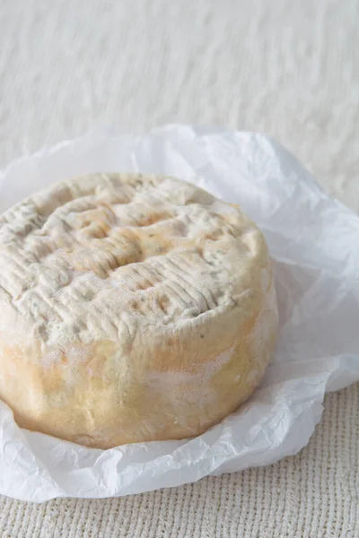 フランスの柔らかい強い香りのチーズマンスター上の白い紙の上に軽い素朴な背景 選択的な焦点 — ストック写真