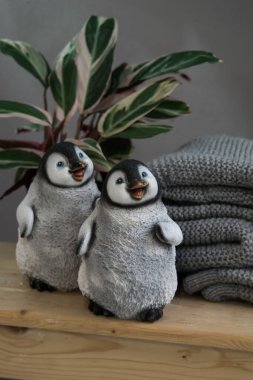 Gri arka planda sevimli beyaz plastik penguenler, seçici odaklanma. Ev dekoru
