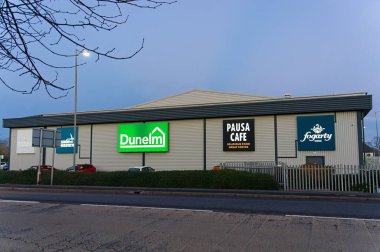 Dunelm süpermarketinde gün batımında alışveriş parkında ışıklı bir tabela var. BOSTON Hughnshire İngiltere.