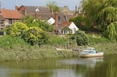 Boston İngiltere 'deki Witham nehrine demirlemiş bir teknesi olan nehir kenarındaki evler.