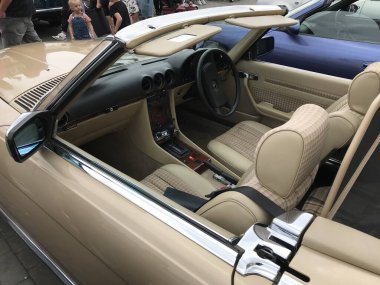 Altın rengi bir Mercedes Benz 280 SL 'in (R107) arka tarafında, Boston' daki bir pazarda klasik bir araba fuarında.