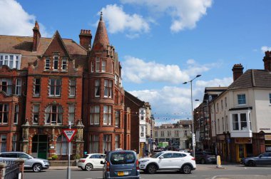 A busy main road off the High street featuring old boarding houses in in Cromer, Norfolk clipart