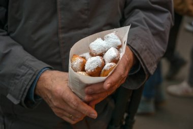 Elinde bir kese dolusu Mutzenmandeln, bademle kaplanmış kızarmış kıtır hamurlu hamur tatlısı Noel, Yeni Yıl ve Karnaval 'da geleneksel Alman ziyafeti çeken adam. Kopya alanı.