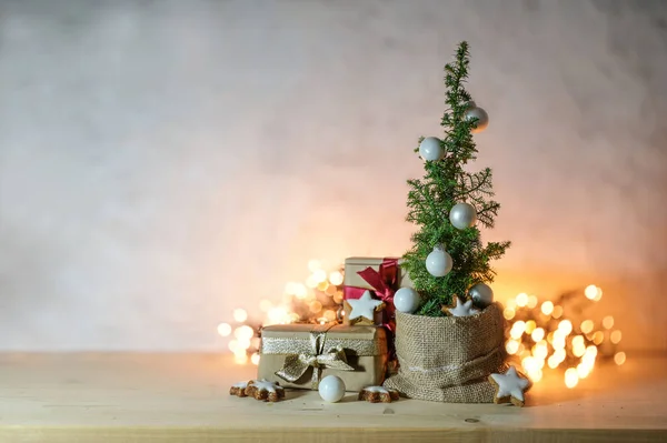 可供选择的空间节约圣诞树 小盆栽的针叶树 装饰着灌木 星星和礼物面前模糊的仙女灯 广阔的复制空间 精心挑选的焦点 — 图库照片