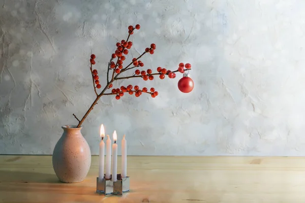 4つの小さなキャンドル 2つの燃焼していると花瓶に赤いクリスマスボールを持つベリーの枝 コピースペースと雪の背景 選択されたフォーカスを持つミニマリズムの2番目の出現 — ストック写真
