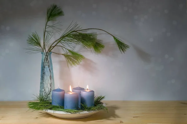 stock image Blue candles, two lit for the seconad advent, and a vase with pine branches, modern decoration in the Christmas season, copy space, selected focus, narrow depth of field