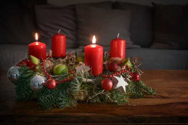 Kanepenin Önündeki Ahşap Masa Üzerinde Iki Yanan Kırmızı Mum Noel — Stok fotoğraf