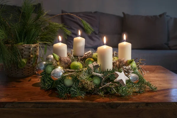 Kanepenin Önündeki Ahşap Masa Üzerinde Dört Yanan Beyaz Mum Noel — Stok fotoğraf