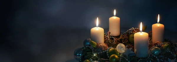 暗い青色の背景 パノラマ形式 コピースペース 選択されたフォーカス フィールドの狭い深さに対するクリスマスの装飾が施された花輪の夜のライト 4つの白いアドベントキャンドル — ストック写真