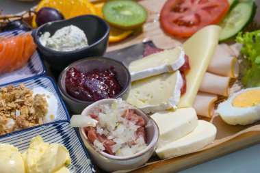 Öğle yemeği ya da kahvaltı için çeşitli malzemelerle açık büfe. Sosis, peynir, meyve reçeli ve seçilmiş odak noktası, dar alan derinliği gibi.