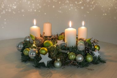 Üçüncü Advent, üç yanan beyaz mum ve yeşil Noel süslemesi olan bir çelenk. Üçüncü Pazar için ev dekorasyonu. Kopya alanı, seçilmiş odak, dar alan derinliği.