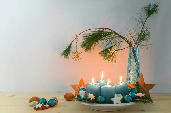 供女修道院用的四支蓝色绿松石蜡烛 圣诞装饰品 盘子上的木星和一个有松枝的花瓶 复制空间 选定的焦点 狭窄的田野深度 — 图库照片