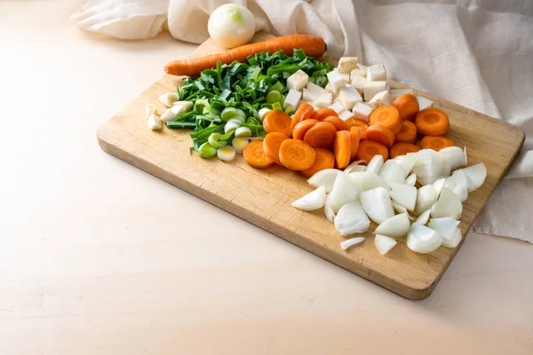 キッチンの木製のまな板にニンジン 玉ねぎ セロリとスープやソースのためのみじん切り野菜 調理コンセプト コピースペース 選択されたフォーカス — ストック写真