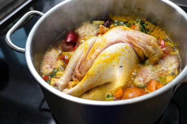 野菜やスパイスとチキンスープは鍋で沸騰している 健康的なスープを調理 風邪やインフルエンザに対する家庭の救済 選択された焦点 フィールドの狭い深さ — ストック写真