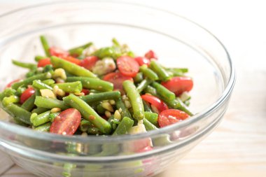 Yeşil fasulye, domates, çam fıstığı ve beyaz peynir salatası açık ahşap bir masada, Akdeniz antipastosu, fotokopi alanı, seçilmiş odak alanı, dar alan derinliği