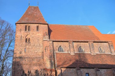Almanya 'nın Rehna kentindeki tarihi manastır kilisesinde, gökyüzü güneşli bir günde, kısmen Romen ve gotik mimari, kısmen kırmızı tuğla duvar ustası ve nav ile mavi gökyüzü