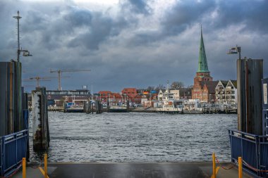 Lubeck Travemunde, Germany, January 15, 2023: Landing stage of the ferry across the river Trave from Priwall to the old town of Travemunde on the Baltic Sea under a dark cloudy sky, copy space