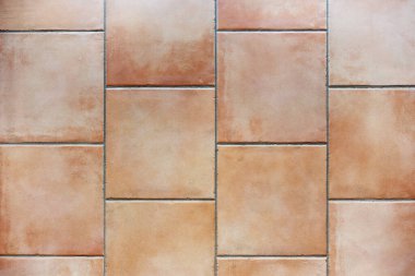 Tiled floor with natural terracotta ceramic tiles and gray grout, background texture, indoor architecture concept, copy space, high angle view from above