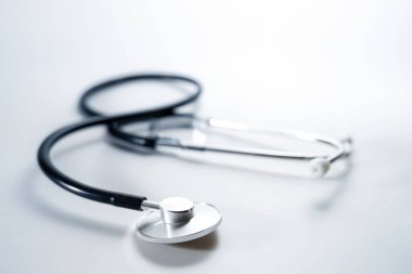 Stethoscope on a light gray background, medical diagnostic device for heart, lungs or digestive tract, copy space, selected focus, narrow depth of field