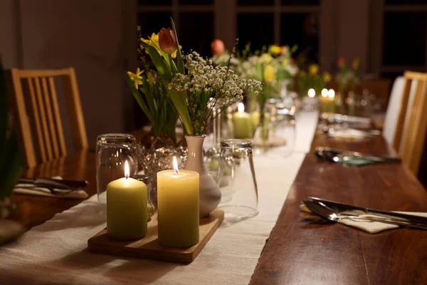 与家人和朋友共进晚餐的餐桌布置 点缀着蜡烛 春花和各种酒杯 布置得井井有条 场地狭小 — 图库照片