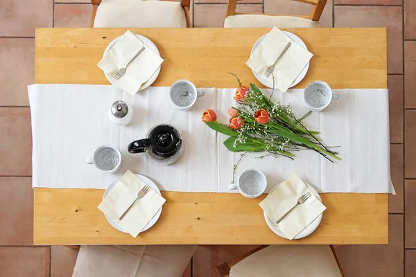 木製のテーブルの上の白いテーブルランナーに4つのプレート カップ ナプキン コーヒーポット チューリップの花 上からのトップビュー 選択されたフォーカスを持つ午後のコーヒーブレイクのための設定 — ストック写真
