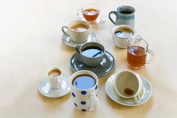 コーヒーや紅茶とガラスから別のカップやマグカップは 光の木製のテーブル コピースペース 選択されたフォーカス フィールドの狭い深さに飲みます — ストック写真