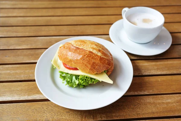 カフェでの朝食 チーズ レタス トマトのパンロール 木製のテーブルの上のコーヒーカップ コピースペース 選択されたフォーカス フィールドの狭い深さ — ストック写真