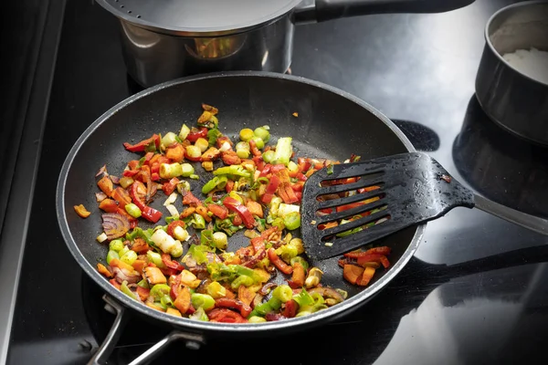 他の鍋で上に黒いフライパンにスパイスでピーマン 玉ねぎ ネギのような揚げ野菜を攪拌 ベジタリアンカレーを調理 コピースペース 選択された焦点 フィールドの狭い深さ — ストック写真