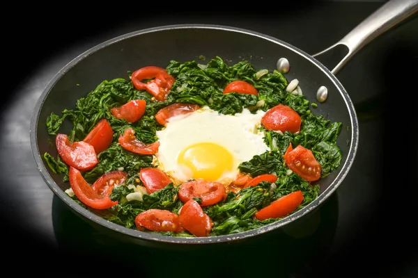 Жареное Яйцо Шпинатом Помидорами Сковороде Черной Плите Приготовление Здоровой Еды — стоковое фото