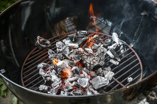 移动圆烤炉 有燃烧的木炭 小火焰和烟雾 烧烤派对的准备 复制空间 选定的焦距 狭窄的场地深度 — 图库照片