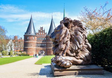 Demir muhafızların aslan heykeli Lubeck Holstentor ya da Holsten kapısı, mavi gökyüzü altında tarihi bir dönüm noktası ve turistik bir yer, Almanya 'nın Luebeck kentinin sembolü, kopyalama alanı, seçilmiş odak noktası.